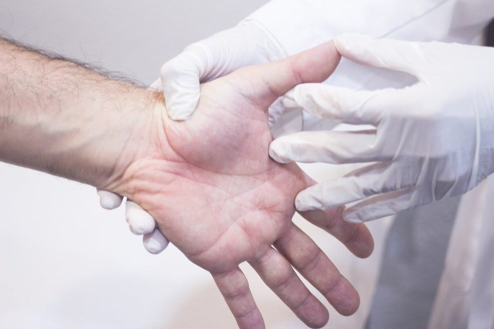 Doctor Examines hand for loss of flexibility from Systemic Sclerosis