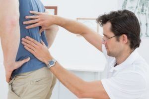 Doctor examining a patients lower back