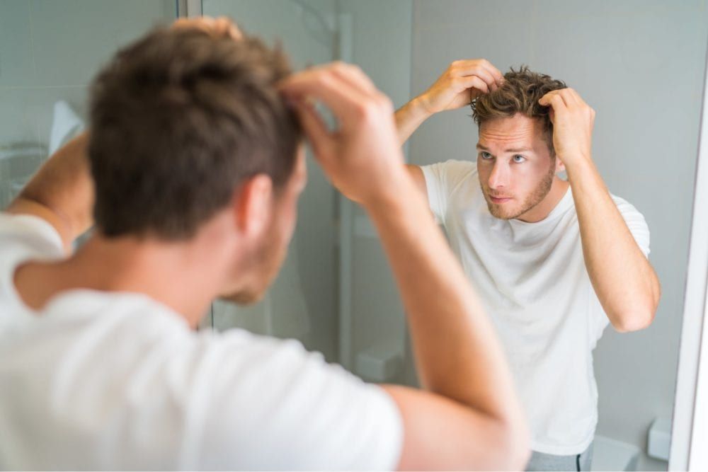 Man Looking In Mirror at Hair